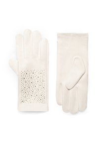 Krémově zbarvené rukavice z měkké tkaniny s hladkou texturou a designem s rozptýlenými zlatými cvočky na jedné rukavici.