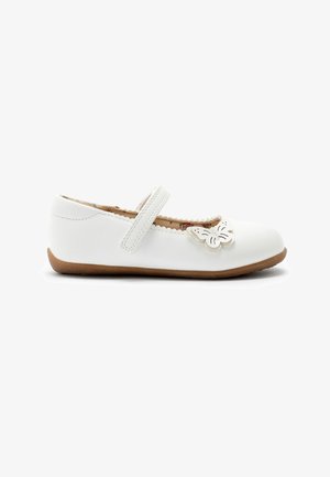 Chaussure d’enfant Mary Jane blanche avec semelle marron, bord festonné, décoration papillon près des orteils et fermeture à bride unique.
