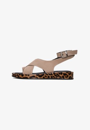 Sandal de tacón bajo de ante beige con diseño de tiras cruzadas, que presenta una plataforma de estampado de leopardo y un detalle de hebilla plateada.