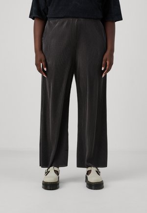 Dark gray wide-leg corduroy pants with vertical stripes, featuring an elastic waistband and side pockets, paired with light-colored shoes.