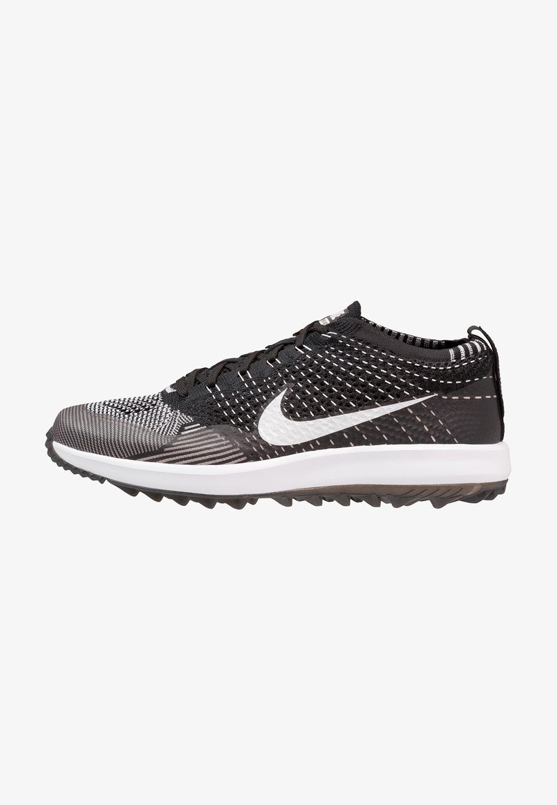 Chaussure de sport Nike noire et blanche avec une tige en mesh texturé, une semelle intermédiaire blanche rembourrée et une semelle extérieure en caoutchouc antidérapante. Talon renforcé et design à lacets.
