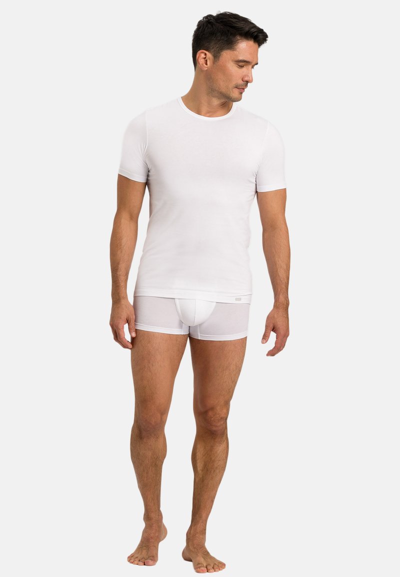 Hvid kortærmet t-shirt og hvide boxershorts, begge lavet af glat stof, med en tætsiddende design og minimalistisk stil.