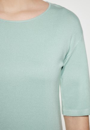 Top in maglia verde menta chiaro con scollatura rotonda e maniche a metà lunghezza. Tessuto liscio, dettaglio a costine lungo i bordi.