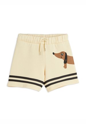 Børneshorts i cremefarve med sorte dobbelte striber nær kanten og en tegneserie brun gravhund trykt på højre ben.