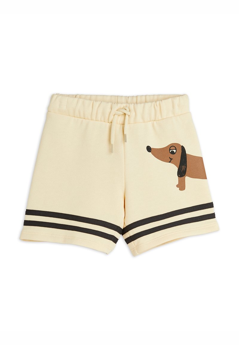 Shorts pour enfants de couleur crème avec des doubles bandes noires près de l'ourlet et un teckel marron en dessin animé imprimé sur la jambe droite.