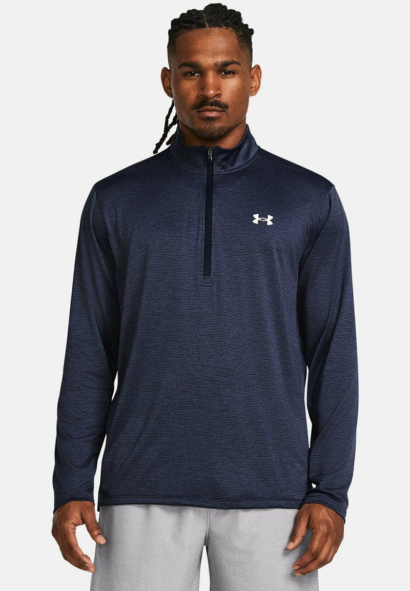 Marineblaues Langarm-Athletikshirt aus strukturiertem Stoff mit einem Viertel-Reißverschlusskragen und einem weißen Logo auf der Brust.
