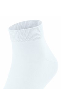 Calzino bianco alla caviglia con polsino a coste e superficie liscia, caratterizzato da un design a taglio basso e un tallone leggermente sagomato.