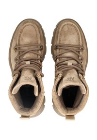 Botines de ante beige con puntera redonda, cuello acolchado y ojales en tono dorado. Disponen de cordones marrones y una suela de goma texturizada.