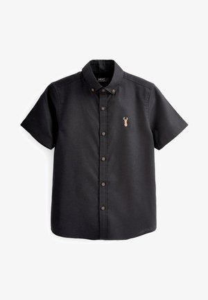 Chemise noire à manches courtes avec col boutonné et petit logo beige en forme de tête de cerf sur la poitrine gauche.