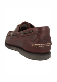 Brązowy skórzany but typu boat z ozdobnym przeszyciem i sznurowaniem. Posiada teksturowany wzór na cholewce oraz gumową podeszwę zapewniającą przyczepność.