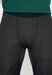 Tights atléticos pretos com textura suave, design ajustado e costuras planas. Cintura alta para conforto e suporte.