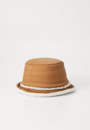 Brown quilted bucket hat with a plush white band around the brim. Cylindrical shape with a soft, textured finish.
