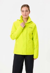 Giacca impermeabile di colore giallo brillante con cappuccio, dotata di zip frontale, polsini elastici e un piccolo logo nella parte superiore sinistra.