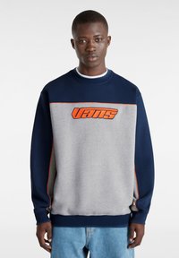 Crewneck sweatshirt med grå kropp och marinblå ärmar, orangea detaljer och en iögonfallande "Vans"-logotyp på bröstet. Material av bomullsblandning.