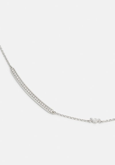 Silverhalsband med en böjd stav med inbäddade klara kristaller, fäst vid ett fint kedja med ett lås för säker stängning.