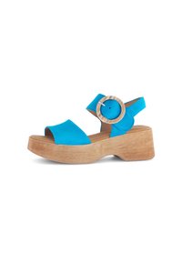 Blauwe platform sandalen met een houten blokhak, voorzien van een brede band en een ronde houten accent op de enkelband. Gladde textuur.
