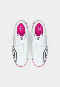 Pantofi de fotbal albi cu accente roz, suprafață texturată și detalii din plasă neagră. Prezintă un design cu șireturi și un guler căptușit pentru confort.