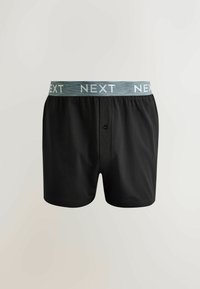 Boxers noirs pour hommes avec une ceinture élastique grise affichant le mot répété "NEXT" en lettres blanches.