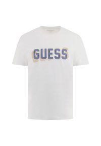 Balta medvilninė marškinė su dideliais, ryškiai mėlynais ir bežiniais „GUESS“ užrašais, kurie išdėstyti centre priekyje. Trumpomis rankovėmis, apvalia iškirpte.