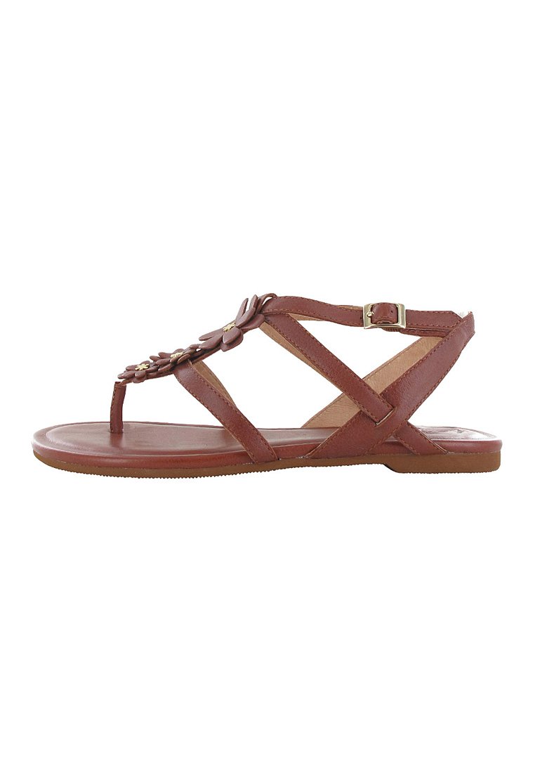 Braune flache Sandale mit Riemen-Design, verstellbarem Knöchelriemen und floralem Schmuck an den vorderen Riemen.