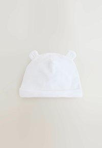 Chapeau en tissu blanc et doux avec un revers plié et deux petits accents en forme d'oreille sur le dessus. Texture lisse et design simple.