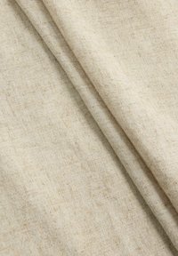 Bežna tkanina z teksturiranim tkanjem, ki vsebuje subtilne barvne razlike in mehko, lahko obliko, lepo zložena.