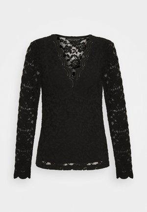 Blouse noire à manches longues en dentelle avec motifs floraux et encolure en V festonnée, design semi-transparent et silhouette ajustée.