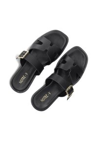 Zwarte leren sandalen met een gestructureerd oppervlak, twee brede banden met uitsparingen en een glanzende gouden gesp op één band.