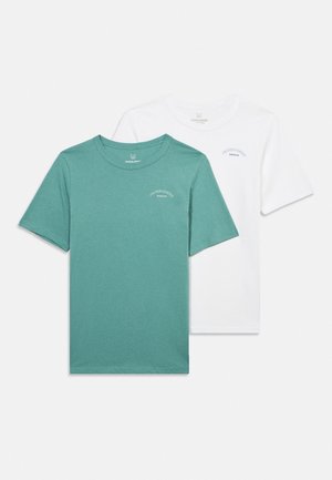 Dve obične majice kratkih rukava s okruglim izrezom, jedna tirkizna i jedna bijela, obje s malim tekstom "Jack & Jones Archive" na lijevoj strani prsa.