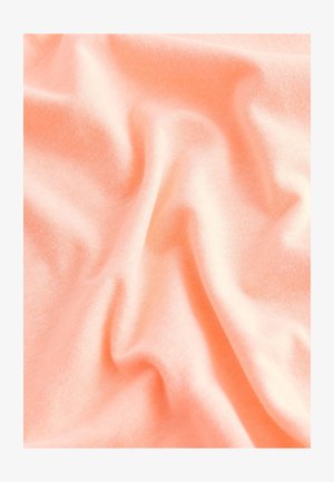 Miękka, brzoskwiniowa tkanina o gładkiej fakturze, z delikatnymi fałdami i zmarszczkami, wskazującymi na lekką i elastyczną strukturę materiału.