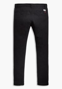 Pantalon en coton noir à coupe droite, avec deux poches arrière, fermetures à boutons, et une petite étiquette de marque près de la ceinture.