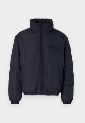 Veste rembourrée noire avec un col montant, fermeture éclair à l'avant, poignets élastiques et ourlet côtelé. Présente une finition texturée avec des coutures horizontales.