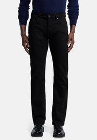 Zwarte denim jeans met een rechte pijpontwerp. Voorzien van een knoop- en ritssluiting, riemlussen en voorzakken. Gladde textuur.