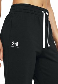 Zwarte katoenen sweatpants met een witte trekkoord. Bevat een geborduurd wit Under Armour-logo op de linkerdij. Glad van textuur.