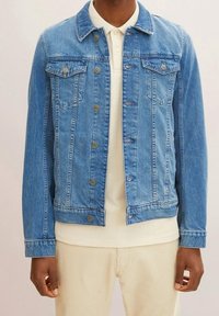 Ljusblå denimjacka med klassisk skärning, med knappstängning, två bröstfickor och en lätt sliten finish.