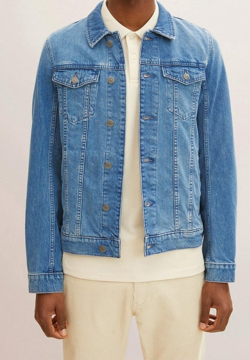 Ljusblå denimjacka med klassisk skärning, med knappstängning, två bröstfickor och en lätt sliten finish.