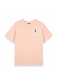 Camiseta de algodón rosa clara con cuello redondo. En la parte frontal presenta un gráfico de una corona negra y la palabra "GRIMEY" en texto blanco arqueado. Tiene mangas cortas.