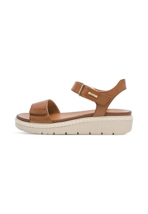 Sandalia de cuero marrón con correa ajustable en el tobillo, plantilla acolchada y suela beige gruesa con agarre texturizado para uso casual.