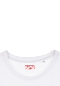 White cotton t-shirt with a round neck. Features a prominent red "MARVEL" logo on the upper center of the shirt. Soft texture.