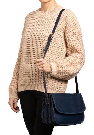 Navy leather crossbody bag with dual compartments, flat flap, and stitching accents. Adjustable strap for versatile wear.