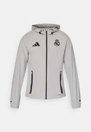 Light gray hooded jacket with black zipper, side pockets, Adidas logo on left chest, and Real Madrid crest on right chest.