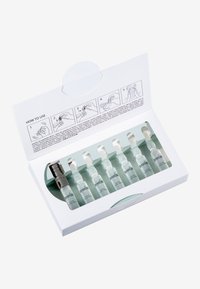 Set of eight clear glass ampoules with white droppers in a mostly white box, featuring a green interior and printed usage instructions.