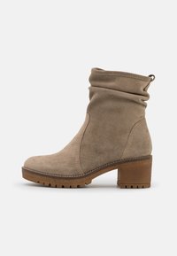 Beige Wildleder-Ankleboot mit einem lässigen Design, runder Zehenpartie und braunem Holzblockabsatz. Verfügt über eine Zugschlaufe und eine strukturierten Gummisohle.