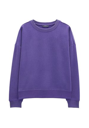 Fioletowy sweter z miękkiego materiału. Posiada okrągły dekolt, opadające ramiona oraz ściągacze na mankietach i u dołu. Prosty design, bez wzorów.