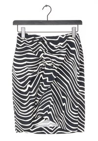 Jupe rayée noir et blanc avec un design tourbillonnant, faite de tissu. Les rayures varient en largeur et créent un effet visuel texturé.