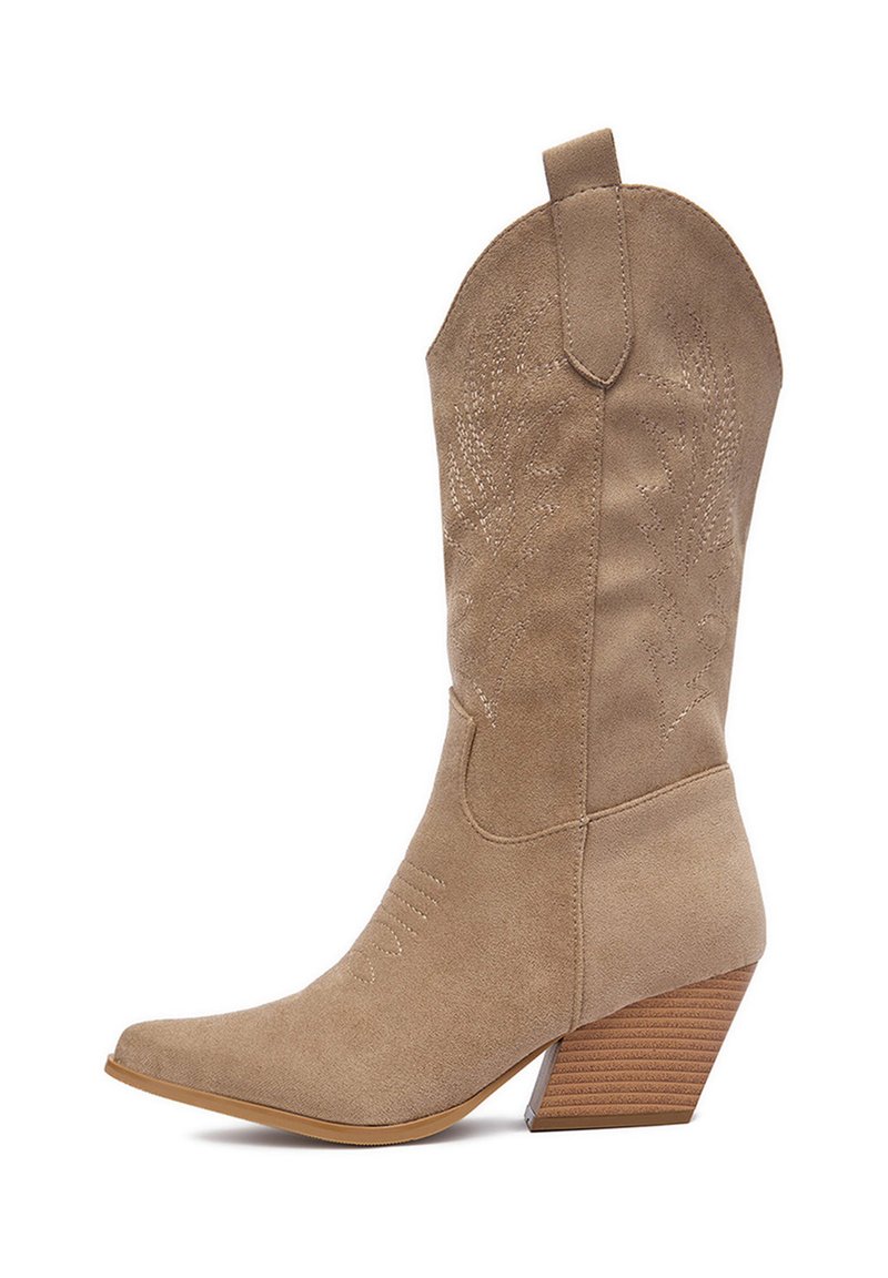 Beżowy zamszowy kowbojski but z zaostrzonym noskiem, skośnym drewnianym obcasem i wytłaczanymi kwiatowymi wzorami na cholewce. Posiada pętelkę ułatwiającą zakładanie.