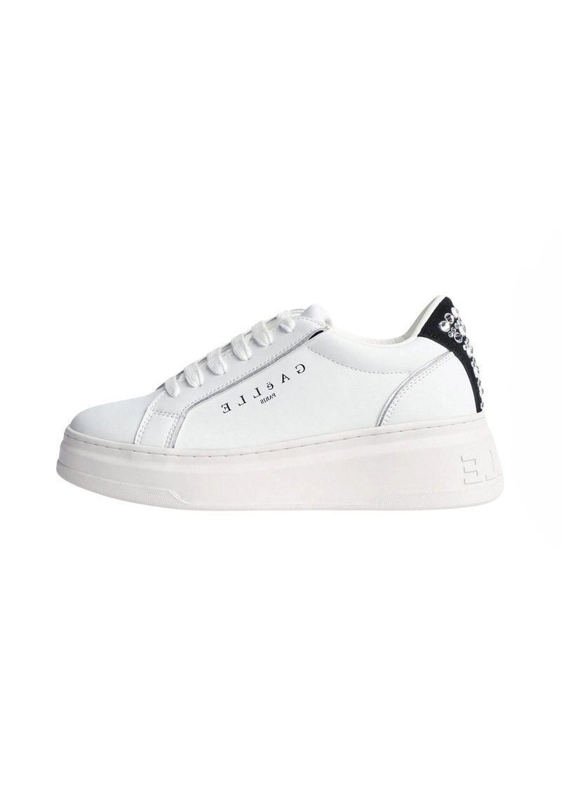 Sneaker bianco con suola piatta, tomaia in pelle liscia, lacci tono su tono, dettaglio neri sul tallone e applicazioni di strass sul retro.