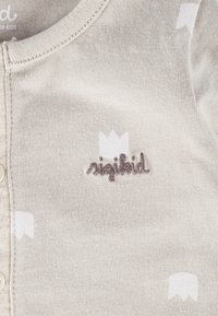 Body per bambini color beige chiaro in morbido cotone. Presenta motivi a corona bianchi e un ricamo del logo "sigikid" marrone scuro vicino al collo.