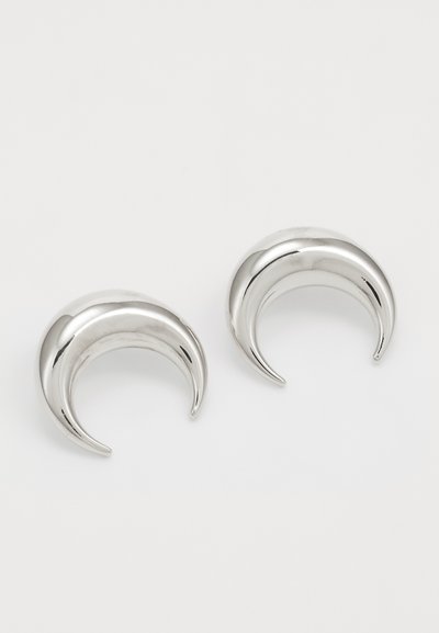 Boucles d'oreilles en argent en forme de croissant avec une finition brillante, présentant une texture lisse et un design courbé, mesurant environ 2 cm de hauteur.