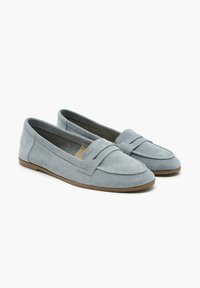 Hellblaue Wildlederslipper mit klassischem Design, featuring einem gesteppten Band über der Vorderseite und einer flachen Gummisohle. Weiche Textur.